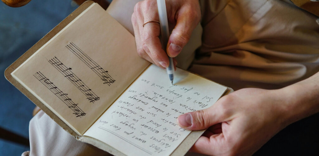 Leerling volgt songwriting les in Utrecht en schrijft in boekje